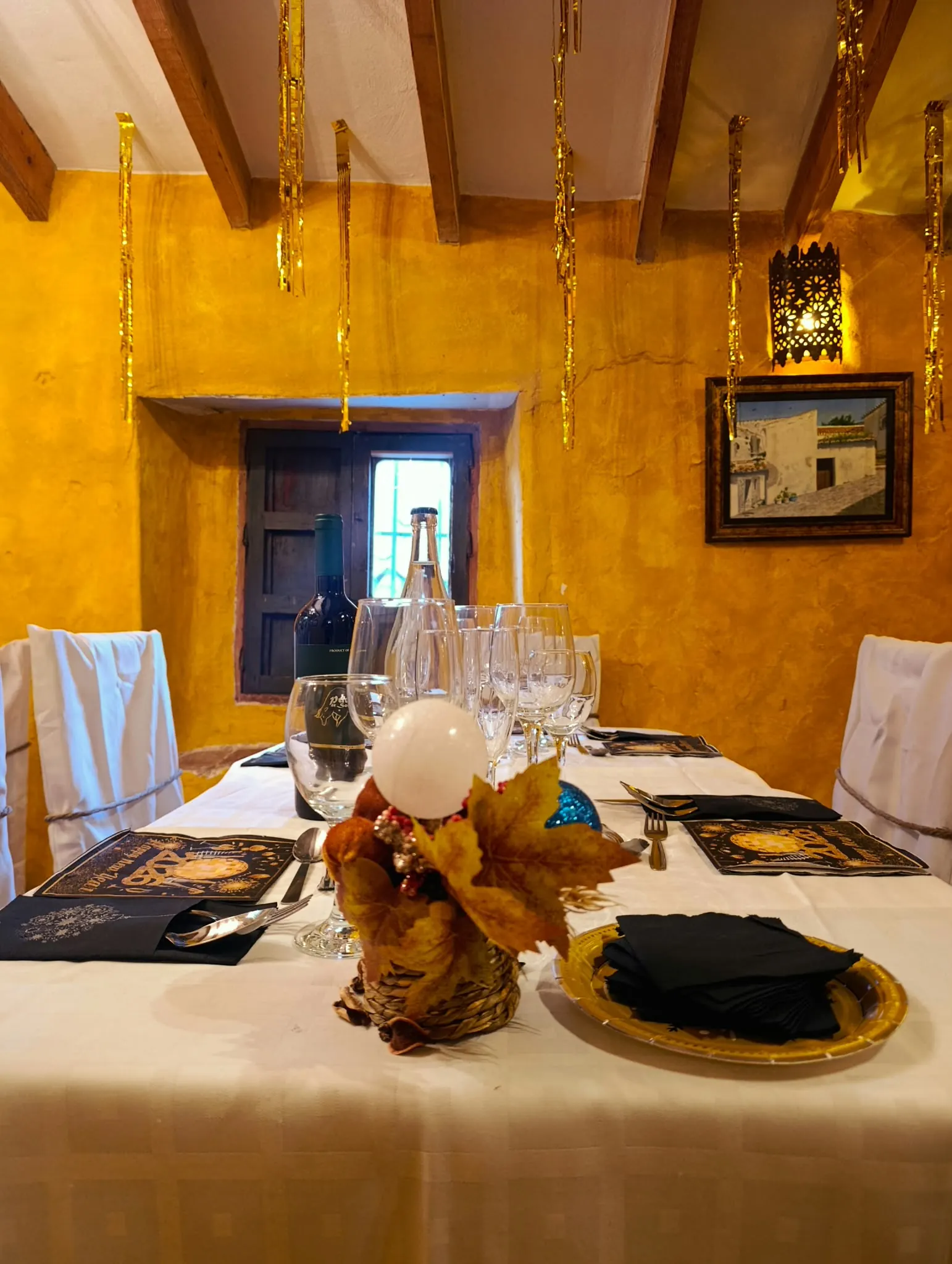 Mesa de fin de año con bajoplatos dorados y un centro de mesa